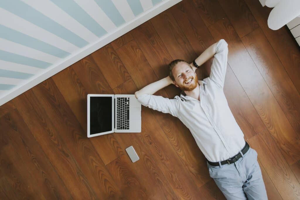 Young man with laptop computer while lying on the floor at home